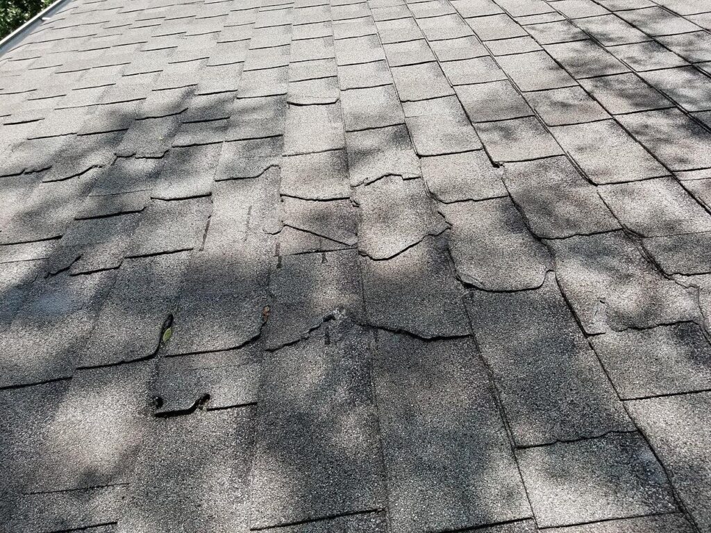 A weathered, hail-worn asphalt shingle roof