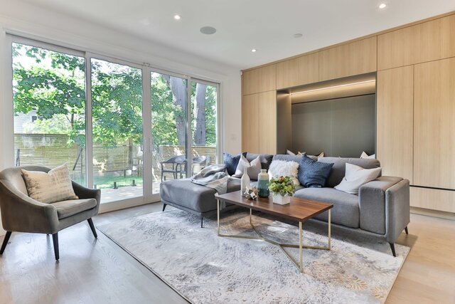 Interior photo of a modern home with large glass doors open to a deck or patio, showing full opening width